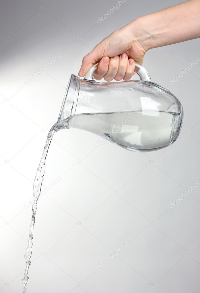 Pouring water from glass pitcher, isolated on white Stock Photo by  ©belchonock 46493351